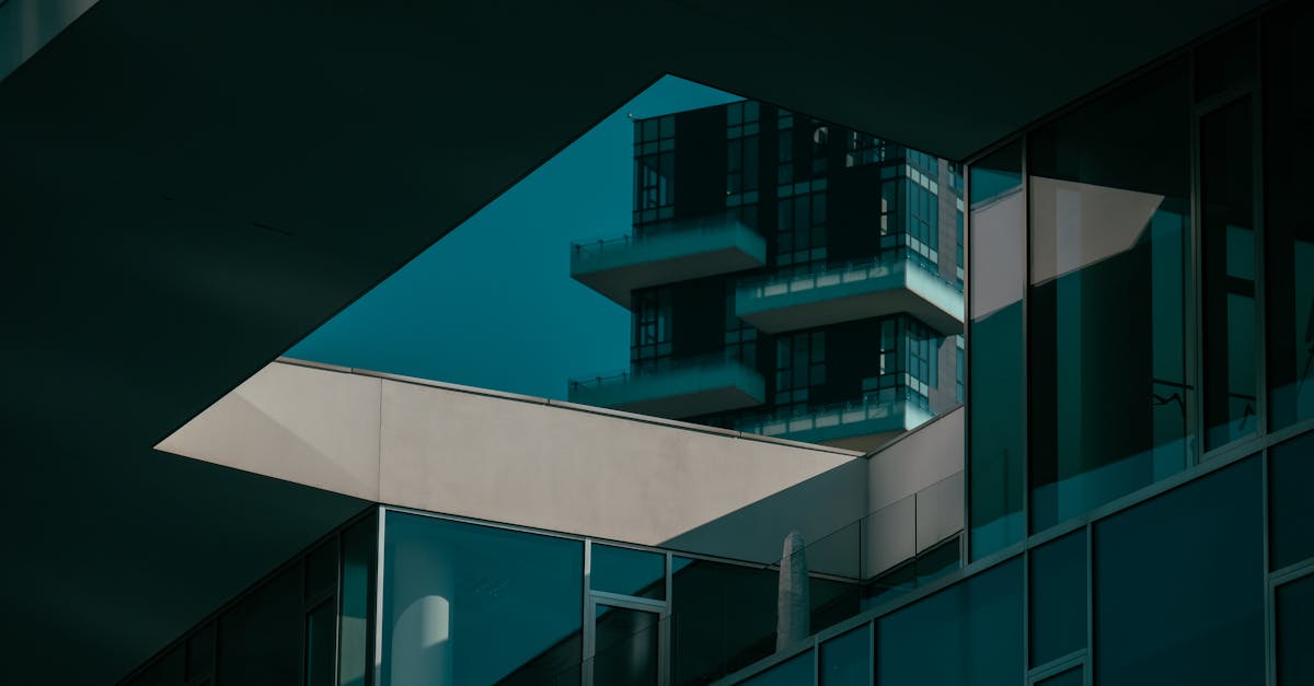 Modern building facade featuring geometric lines and glass reflections in an urban setting.